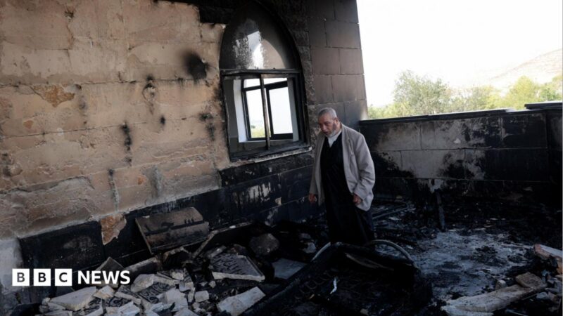 A Palestinian man inspects the damage at a mosque, which Palestinians say was damaged by Israeli settlers, in Qusra near
