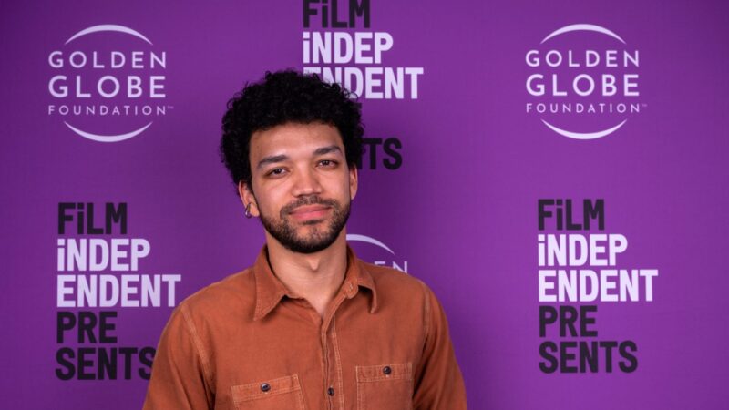 Justice Smith in front of a purple FilmIndependent backdrop