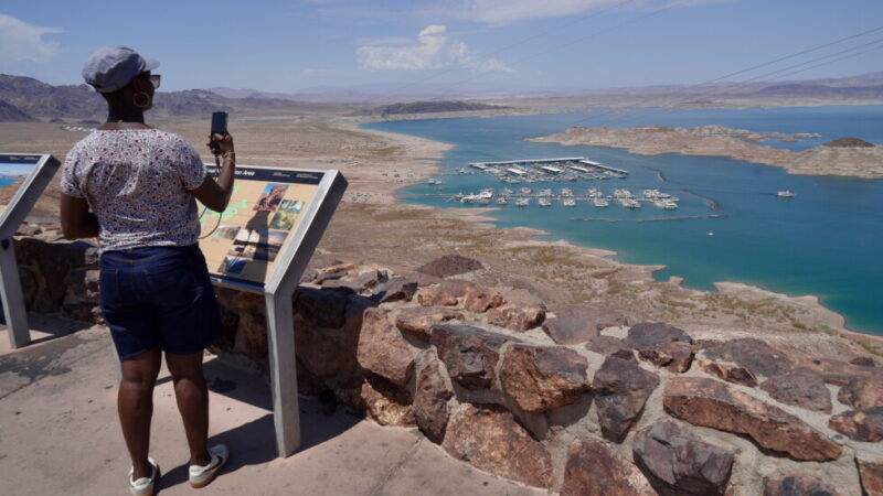 A tourist takes a photo of Lake Mead near Boulder City, Nev., on Friday, Aug. 7, 2026. (AP Photo/Ty ONeil)