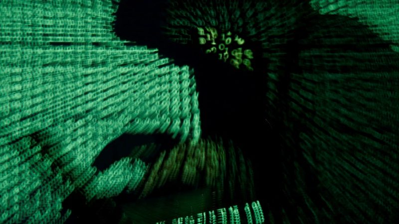 A man holds a laptop computer as cyber code is projected on him in this illustration picture taken on May 13, 2017