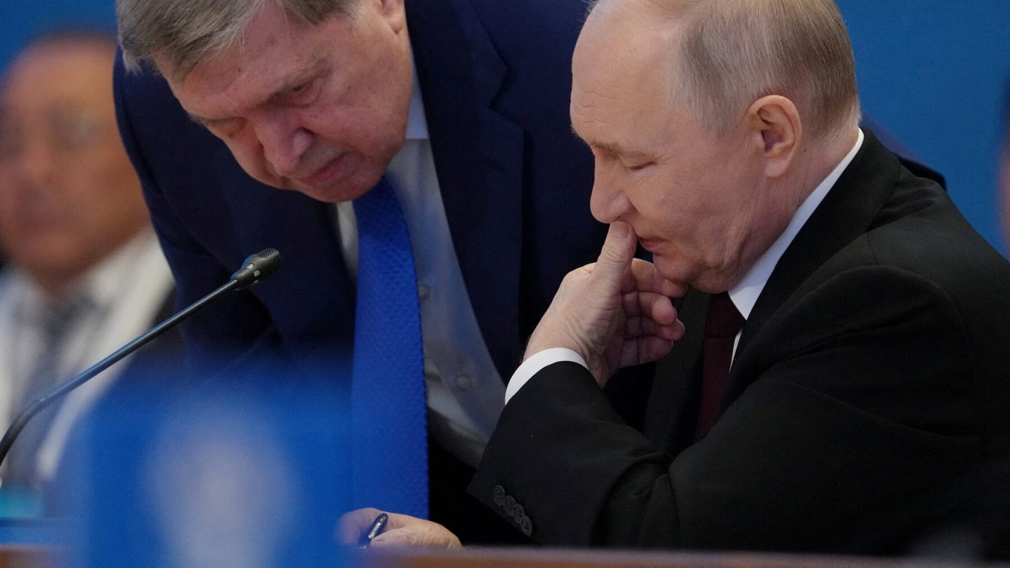 Russian President Vladimir Putin speaks to his aide, Yuri Ushakov, during the summit of the Supreme Eurasian Economic