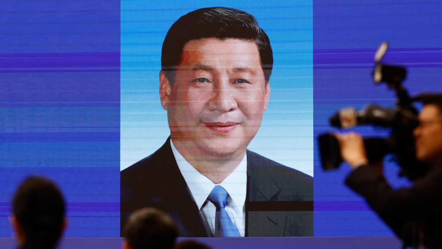 A portrait of Chinese President Xi Jinping is seen on the screen as participants attend the opening ceremony for the